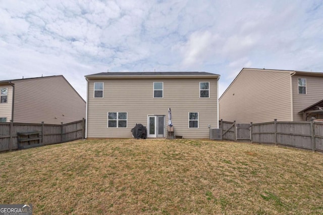 rear view of property with a yard and central AC unit