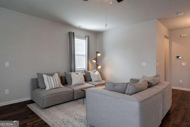 living room with dark wood-type flooring and ceiling fan