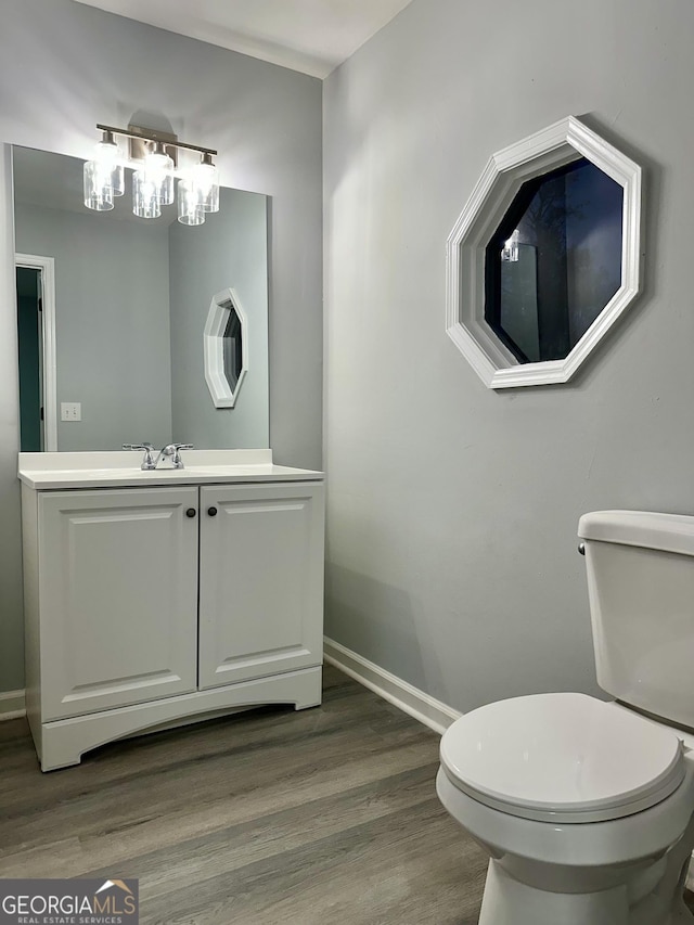 bathroom with vanity, toilet, and hardwood / wood-style floors