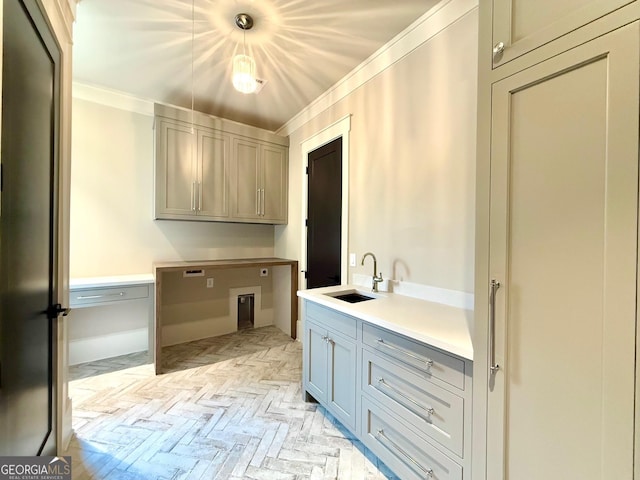 laundry area with brick floor, hookup for a washing machine, cabinet space, ornamental molding, and a sink