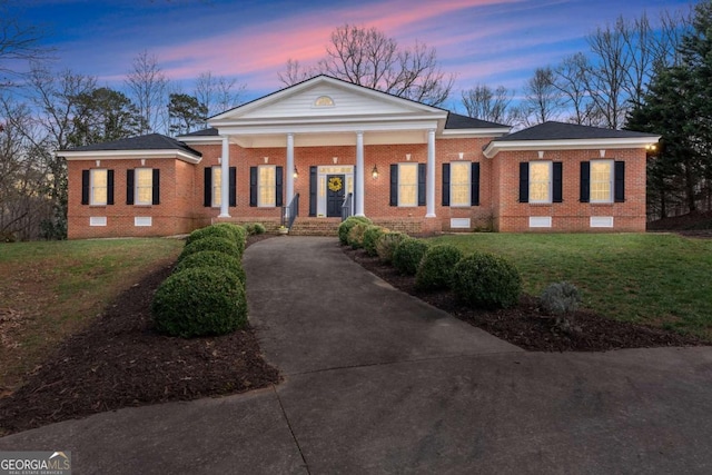 neoclassical home with a yard and a porch