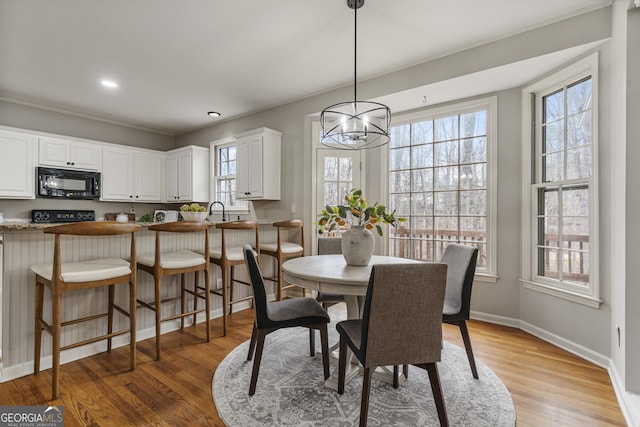 dining space with light wood finished floors, plenty of natural light, and baseboards