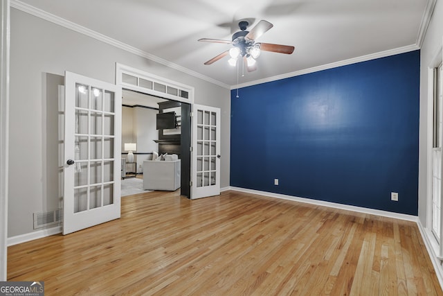 spare room featuring ornamental molding, french doors, wood finished floors, and a ceiling fan