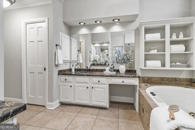 full bath with a garden tub, tile patterned flooring, vanity, and baseboards