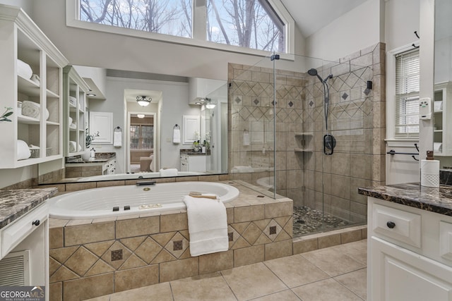 bathroom featuring a garden tub, tile patterned floors, a wealth of natural light, and vanity