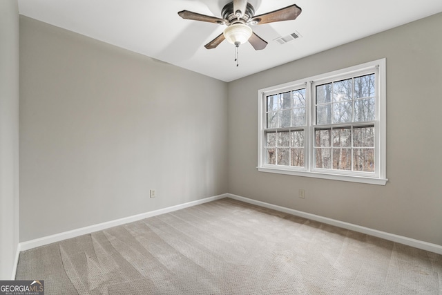 carpeted spare room featuring visible vents, ceiling fan, and baseboards