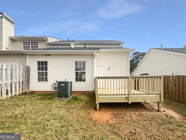 back of house featuring cooling unit, a deck, and a lawn