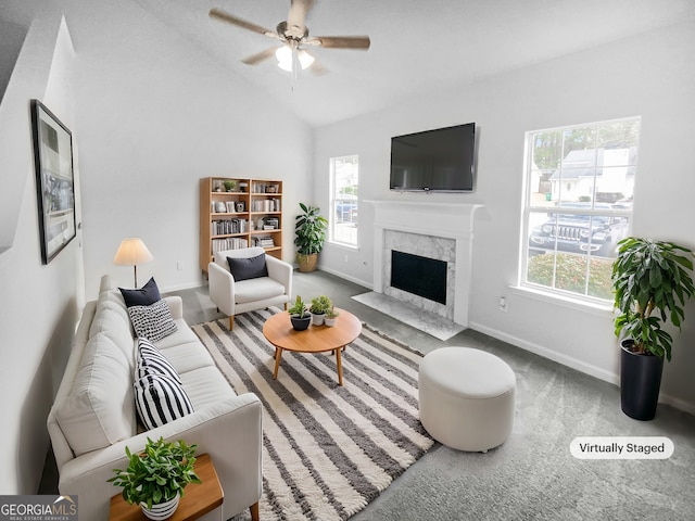 carpeted living room with ceiling fan, a premium fireplace, and vaulted ceiling