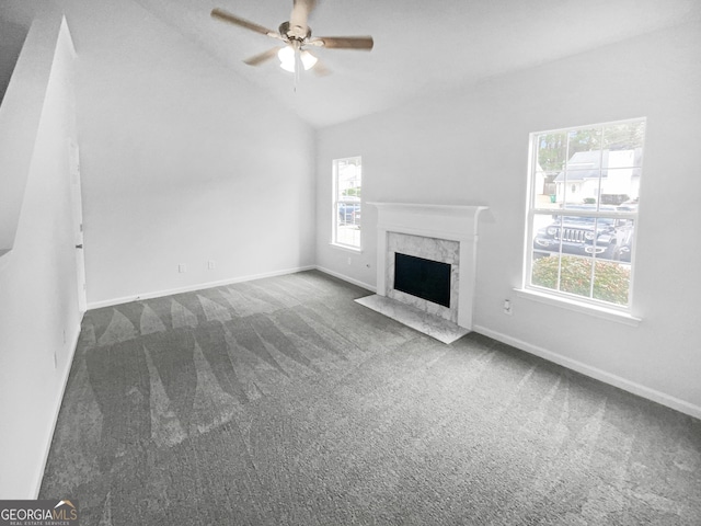 unfurnished living room with vaulted ceiling, ceiling fan, a premium fireplace, and carpet floors