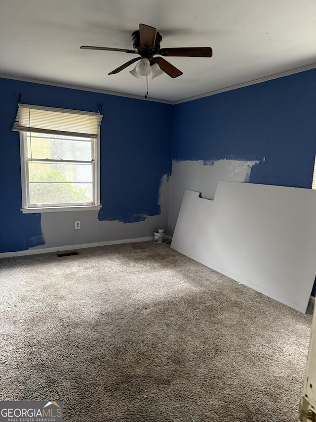 spare room featuring ornamental molding, carpet flooring, and ceiling fan