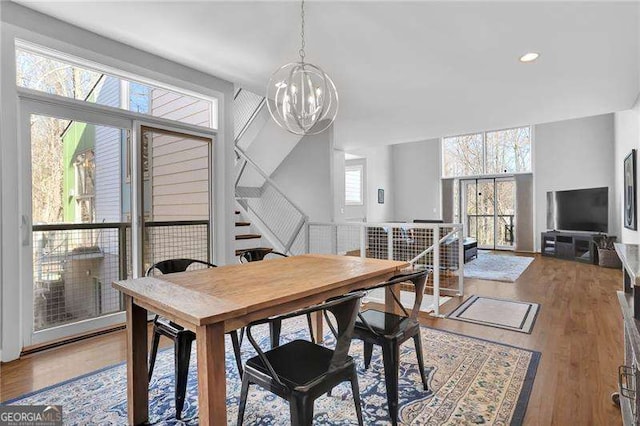 dining area featuring hardwood / wood-style flooring and an inviting chandelier