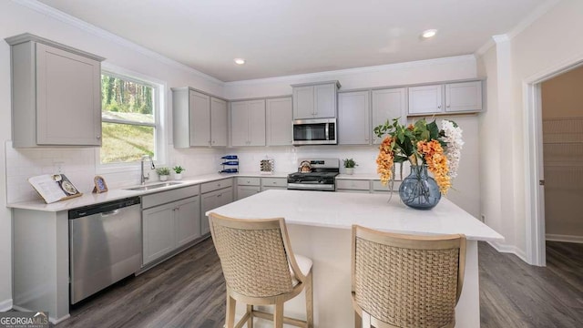 kitchen featuring stainless steel appliances, tasteful backsplash, gray cabinets, and dark wood-type flooring