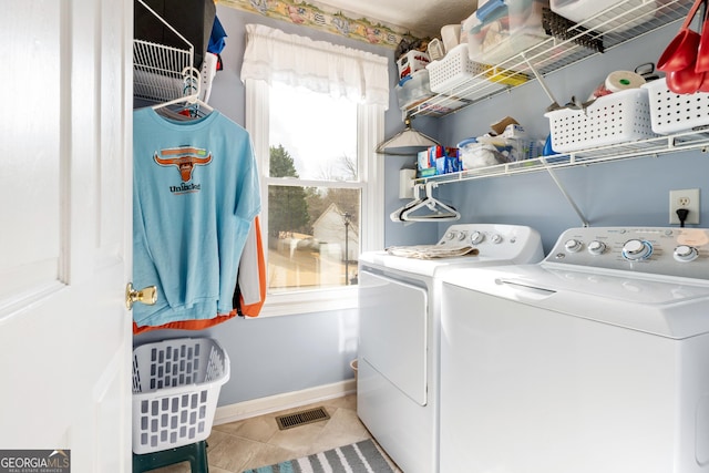 clothes washing area with independent washer and dryer and light tile patterned flooring