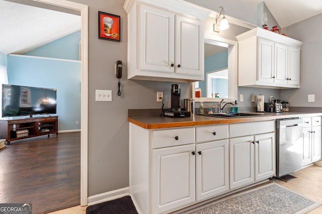 kitchen featuring sink, dishwasher, white cabinetry, vaulted ceiling, and light wood-type flooring