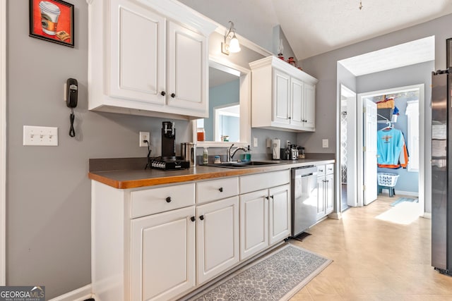 kitchen with white cabinetry, dishwasher, and sink