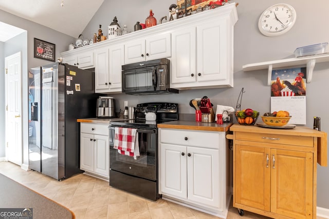 kitchen with lofted ceiling, white cabinets, butcher block countertops, and black appliances