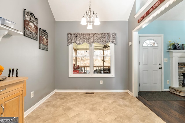 foyer entrance featuring vaulted ceiling and a notable chandelier