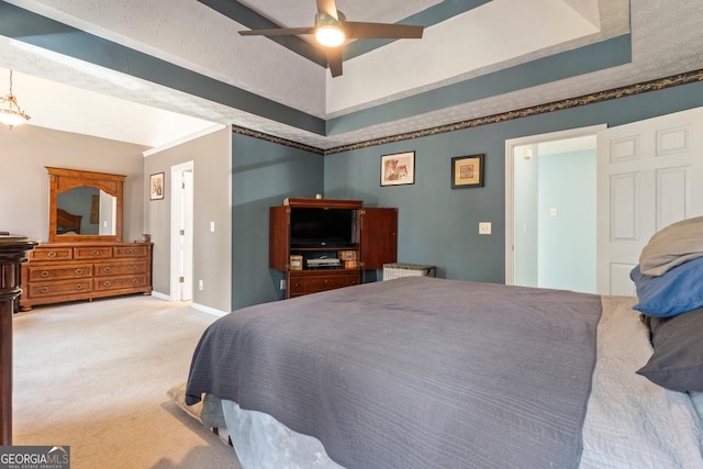 carpeted bedroom featuring a raised ceiling and ceiling fan