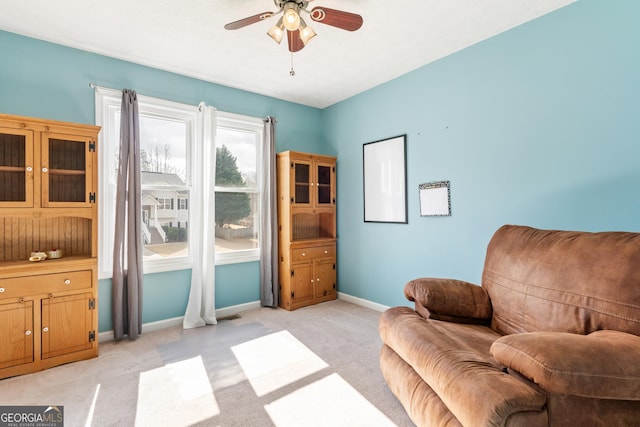 sitting room with ceiling fan and light carpet