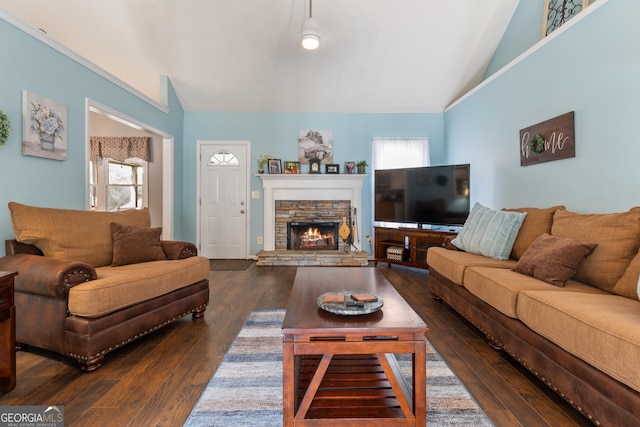 living room featuring lofted ceiling, dark hardwood / wood-style floors, a wealth of natural light, and a fireplace