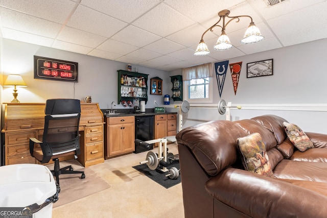 home office with light carpet, a paneled ceiling, and wet bar