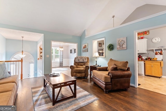 living room featuring an inviting chandelier, dark hardwood / wood-style flooring, and vaulted ceiling