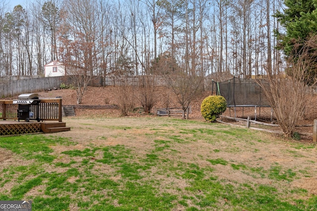 view of yard featuring a deck and a trampoline