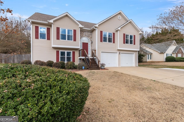 split foyer home featuring a garage and a front yard