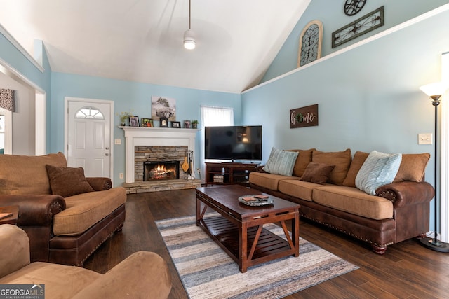 living room with a stone fireplace, dark wood-type flooring, and high vaulted ceiling