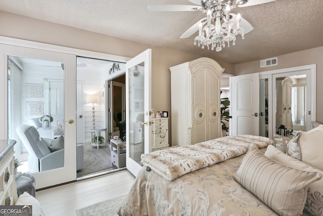 bedroom featuring ceiling fan, light hardwood / wood-style floors, french doors, and a textured ceiling