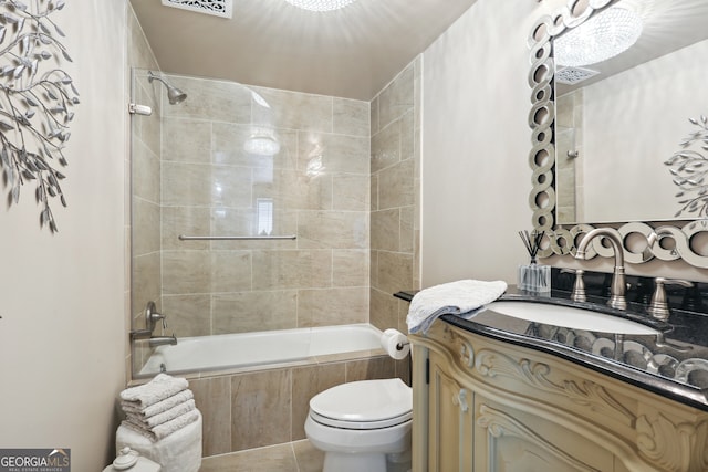 full bathroom with vanity, tiled shower / bath combo, tile patterned floors, and toilet