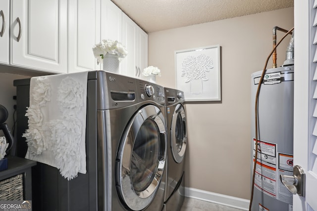 laundry room featuring a textured ceiling, gas water heater, cabinets, and washing machine and clothes dryer