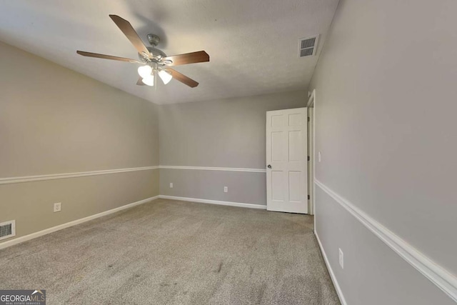 spare room featuring ceiling fan and carpet