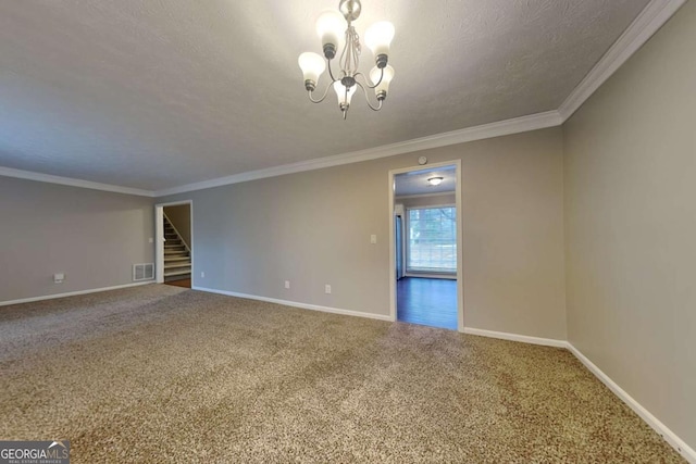 spare room featuring ornamental molding, carpet, a textured ceiling, and an inviting chandelier