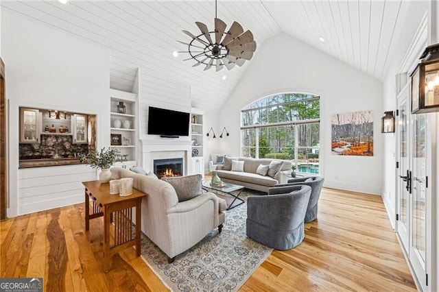 living room featuring wood ceiling, built in features, high vaulted ceiling, french doors, and light wood-type flooring