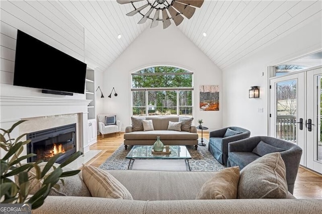 living room featuring french doors, ceiling fan, high vaulted ceiling, and light hardwood / wood-style floors