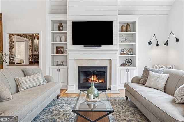 living room with built in shelves and light hardwood / wood-style floors