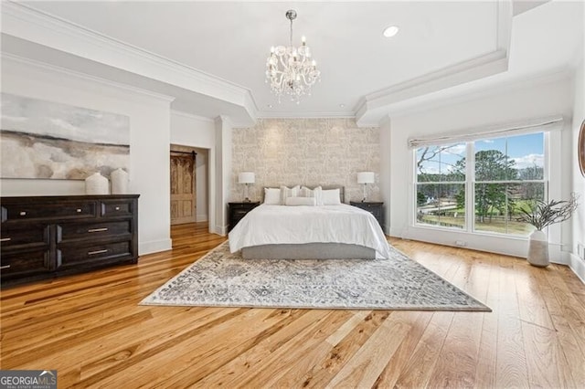 bedroom featuring ornamental molding, light hardwood / wood-style floors, and a chandelier