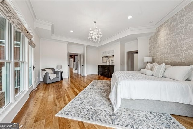 bedroom with crown molding, an inviting chandelier, and light hardwood / wood-style floors