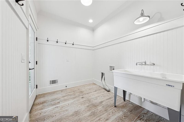 washroom with washer hookup, crown molding, and light wood-type flooring