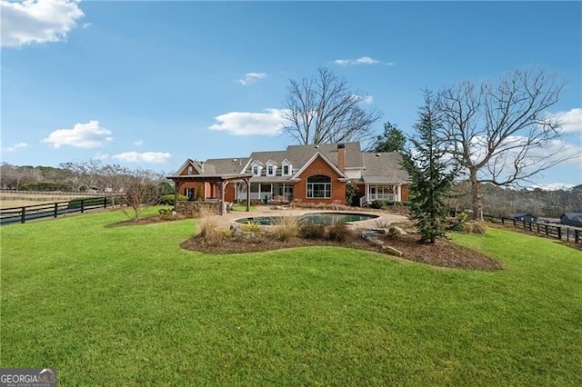 rear view of house featuring a yard and a rural view