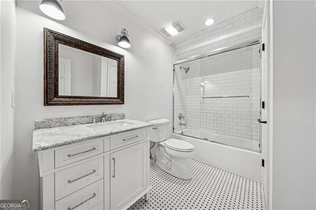 full bathroom featuring toilet, ornamental molding, vanity, and bath / shower combo with glass door