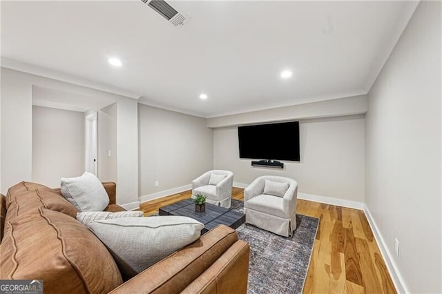 living room with crown molding and light hardwood / wood-style floors