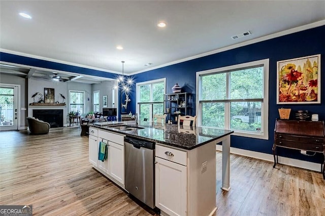 kitchen featuring a sink, white cabinetry, open floor plan, stainless steel dishwasher, and visible vents