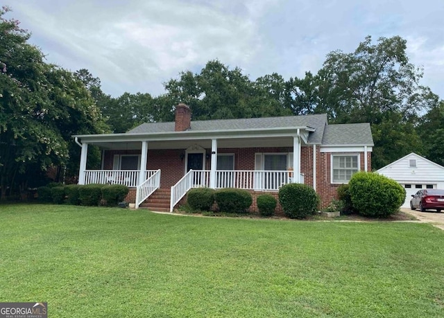 view of front of property with a garage, an outdoor structure, a front yard, and covered porch