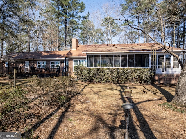 back of property featuring a deck and a sunroom