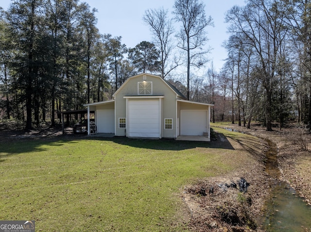 garage featuring a carport and a lawn