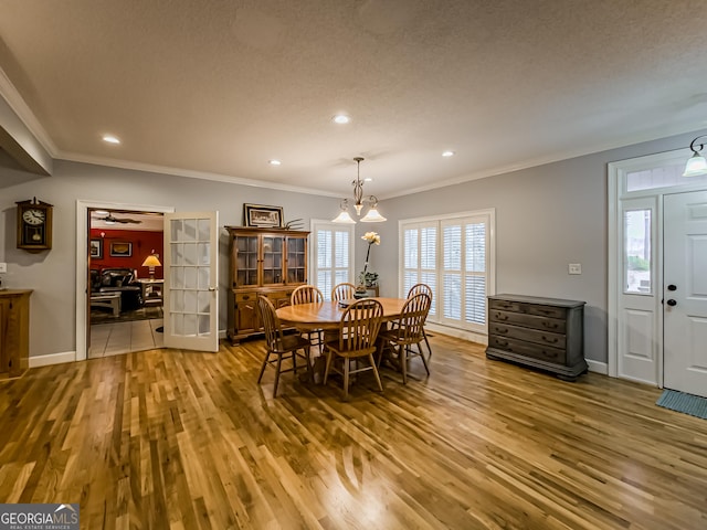 dining space featuring ornamental molding, a textured ceiling, and hardwood / wood-style floors