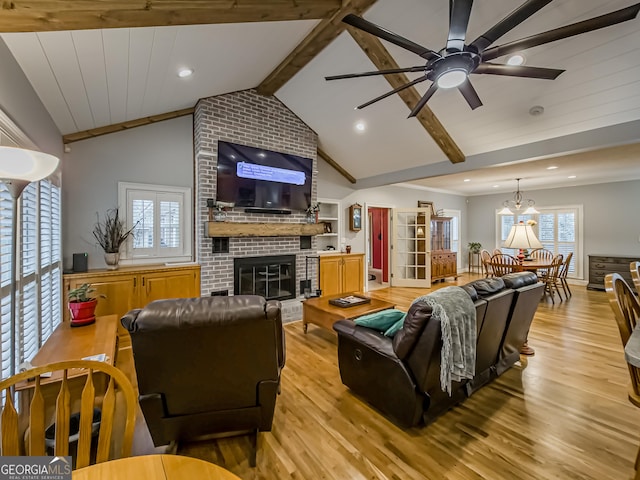 living room featuring light wood-type flooring, ceiling fan, lofted ceiling with beams, and a fireplace