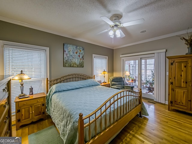 bedroom with hardwood / wood-style floors, crown molding, access to exterior, and a textured ceiling